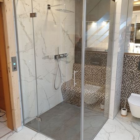 Glasdusche auf Fliesen mit Marmormuster