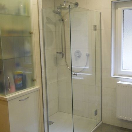 Glasdusche mit hellem Untergrund und Hintergrund