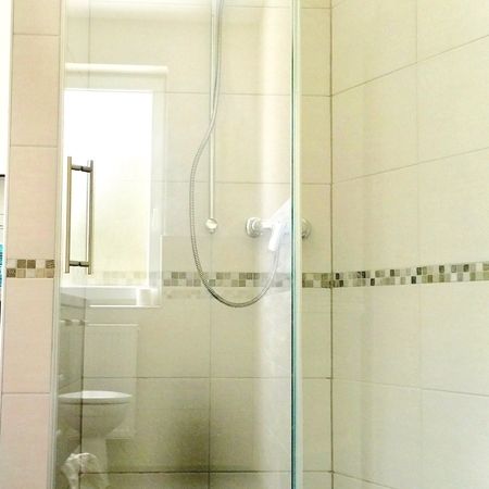 Glasdusche auf dunklen Fliesen