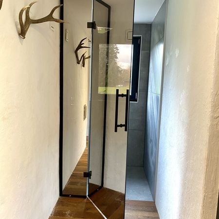 Spiegelnde Glasdusche mit geöffneter Tür