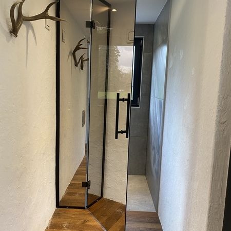 Spiegelnde Glasdusche mit geöffneter Tür