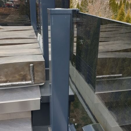 Seitenansicht eines dunklen Balkonglasgeländers auf Treppen