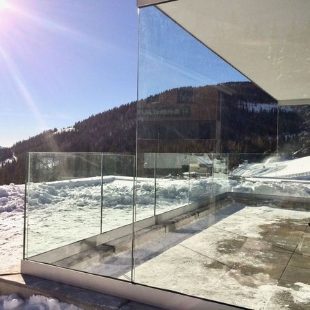 Glasgeländer vor beschneiter Landschaft