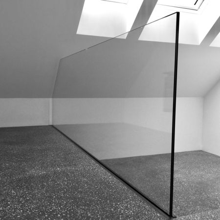 Glas-Raumtrenner in leerem Raum mit Dachschräge