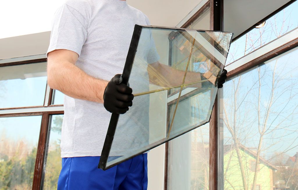 Mann mit Fensterglas in den Händen